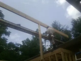 Carpenter setting a ridge beam over a new addition frame — Ice Dam Removal by Roofing Brothers in Horse Cave
