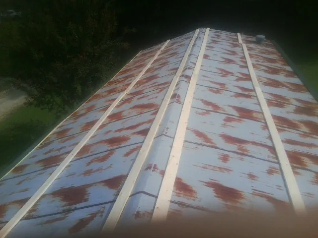 Rusted metal roof panels with new wood purlins before replacement — Storm Damage Roof Repair in Horse Cave by Roofing Brothers
