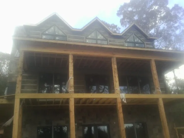 Dormers and porch framing on a large log home under construction — Roof Coating work by our crew in Horse Cave