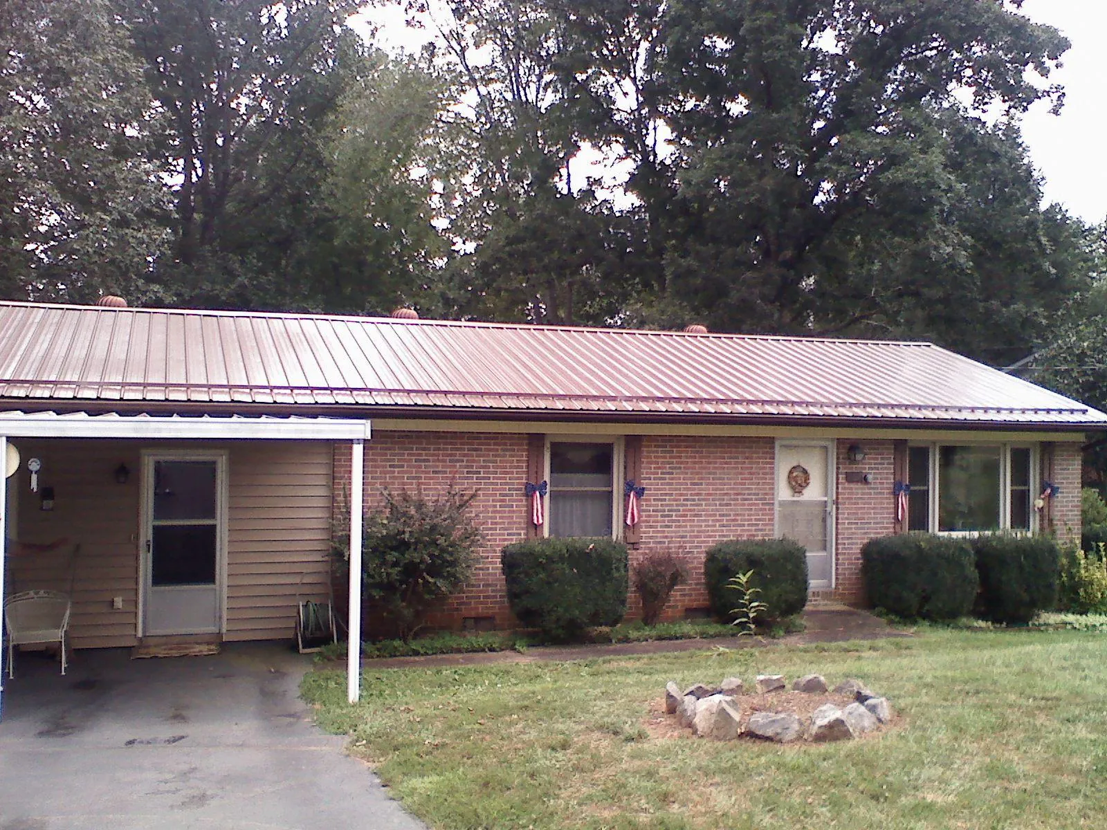 Bronze metal roof and carport on a brick ranch home — Roof Repair work by our crew in Horse Cave